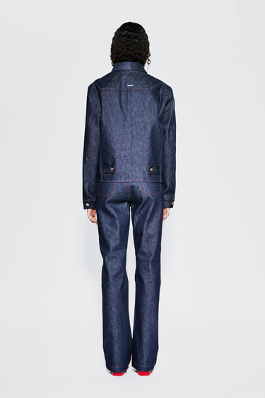 Raw denim jacket back view on female model, showing adjustable straps and stitching