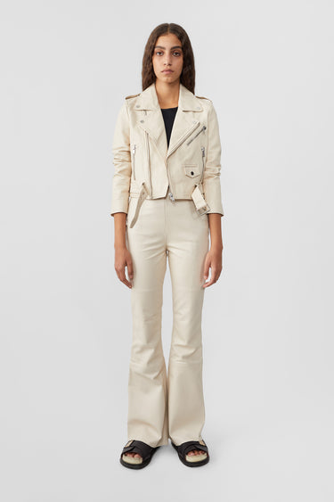 Model in Joan Cropped Leather Jacket in Off White by Deadwood, featuring a practical inside pocket, made from recycled leather with eco-friendly lining.
