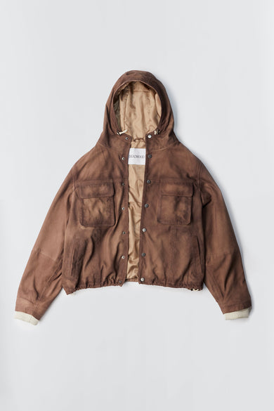 Flat view of oversized hip-length parka in brown recycled suede with large chest pockets, hood, and snap button closure.
