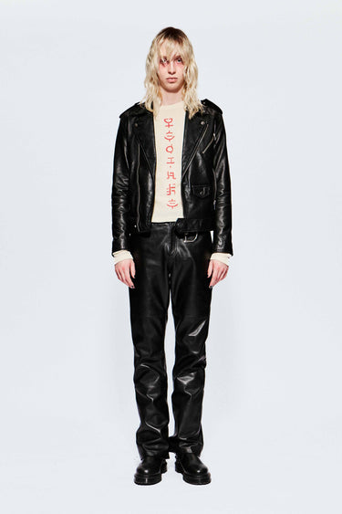 Front image of model wearing a black leather biker jacket and leather pants on a white background.