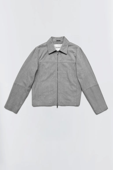Steele is a grey overshirt made from recycled suede with a boxy fit. It features a front zipper in silver, combining modern style with sustainable materials.