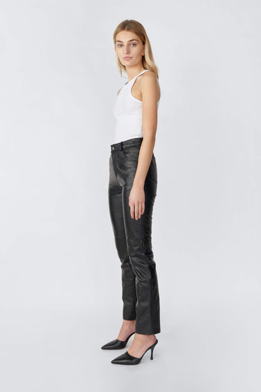 Model in side profile wearing black Phoenix slim-fit leather pants by Deadwood, made from recycled leather and PET bottles.