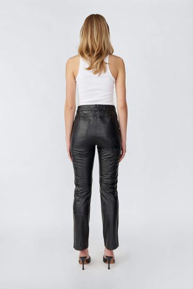 Backside of model wearing black Phoenix slim-fit leather pants by Deadwood, made from recycled leather and PET bottles.