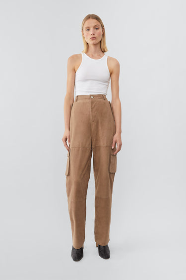 Model wearing Deadwood straight cut cargo pants with slightly dropped crotch, zip fly and workwear-inspired double waist pockets and leg pockets. One 32” length fits all. In color sand.  Made from recycled suede. 