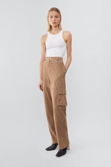 Model wearing Deadwood straight cut cargo pants with slightly dropped crotch, zip fly and workwear-inspired double waist pockets and leg pockets. One 32” length fits all. In color sand.  Made from recycled suede. 