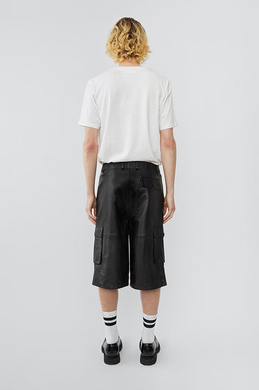 Model wearing black mid length Deadwood cargo shorts made from deadstock leather.