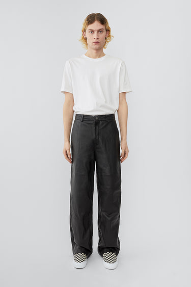 Model wearing wide straight cut Deadwood leather pants with high waist, zip fly and workwear inspired front pocket detail. Flattering jean style back pockets. Made from recycled leather.