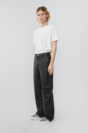 Model wearing wide straight cut Deadwood leather pants with high waist, zip fly and workwear inspired front pocket detail. Flattering jean style back pockets. Made from recycled leather.