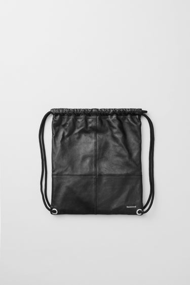 The Drawstring is a unisex tote bag with sturdy shoulder ropes, drawstring enclosure, and practical inside zip pocket. Made from recycled leather.