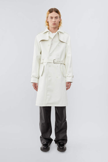 Model wearing white Deadwood military-inspired trench coat in vegan cactus leather. Classic details such as belt, flap yokes at shoulders and back, and slit at bottom hem.