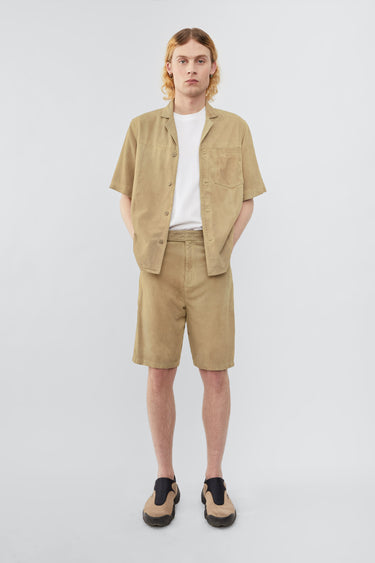 Model wearing Deadwood short sleeve suede shirt in the color lime, inspired by vintage hawaiian shirts. Made from recycled suede.