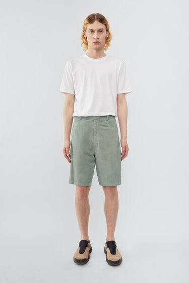 Model wearing Deadwood knee-length suede board shorts in the color ice. Hook and zipper closure and right back pocket. Made from recycled suede.