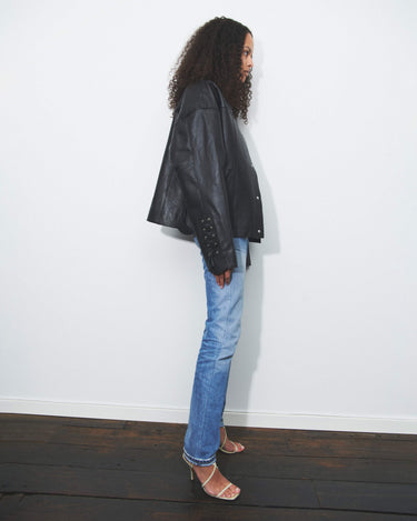 Model wearing black Deadwood oversized leather jacket as a true statement piece. Leather rope features at cuffs and sides. Made from heavy recycled leather. 
