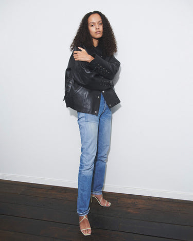 Model wearing black Deadwood oversized leather jacket as a true statement piece. Leather rope features at cuffs and sides. Made from heavy recycled leather. 