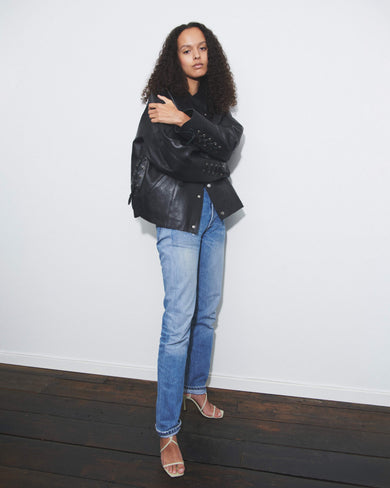 Model wearing black Deadwood oversized leather jacket as a true statement piece. Leather rope features at cuffs and sides. Made from heavy recycled leather. 