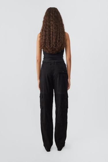 Model from the back in black Convoy Suede Pants by Deadwood, workwear-inspired cargo pants in upcycled goat suede with a tapered fit and eco-conscious materials.
