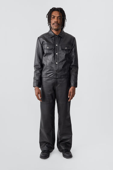 Model wearing trucker-inspired Deadwood leather jacket. It comes with button closure and flap pockets on the chest. Made from recycled leather.