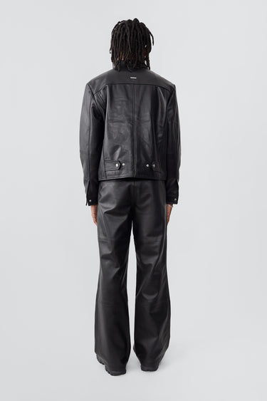 Model wearing trucker-inspired Deadwood leather jacket. It comes with button closure and flap pockets on the chest. Made from recycled leather.