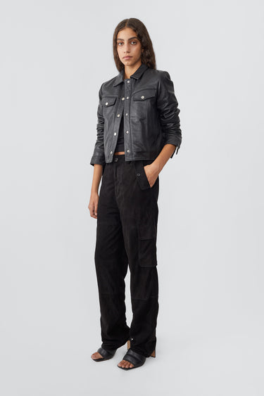 Model wearing trucker-inspired Deadwood leather jacket. It comes with button closure and flap pockets on the chest. Made from recycled leather.