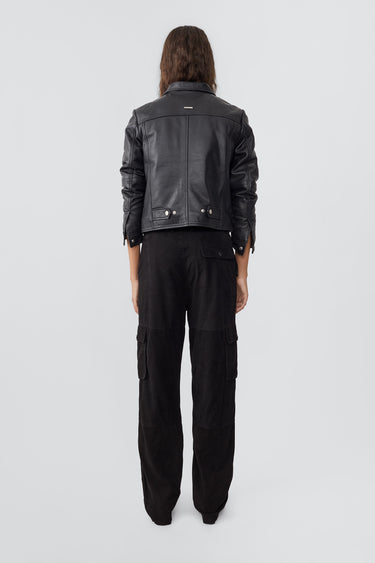 Model wearing trucker-inspired Deadwood leather jacket. It comes with button closure and flap pockets on the chest. Made from recycled leather.