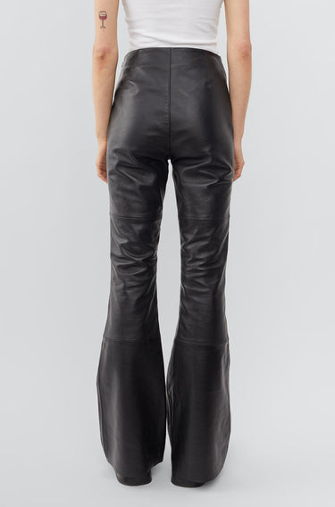 Model from the back in black leather Kick Pants by Deadwood, slim-fit Y2K kick-flare with sustainable recycled materials.