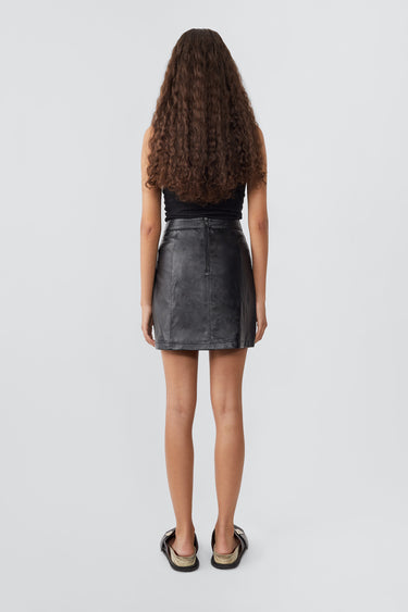 Model in black Lena recycled leather mini skirt by Deadwood, above-knee length with back zip closure.