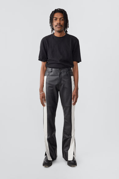 Model in Prance Leather Pants in black with white stripes and slits at leg opening, made from upcycled lambskin.