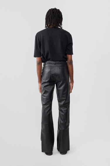Model in Prance Leather Pants in black with white stripes and slits at leg opening, made from upcycled lambskin.