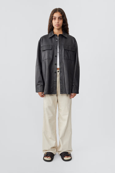 Model wearing Shoreline black leather over-shirt by Deadwood, made from upcycled leather and recycled plastic bottles.