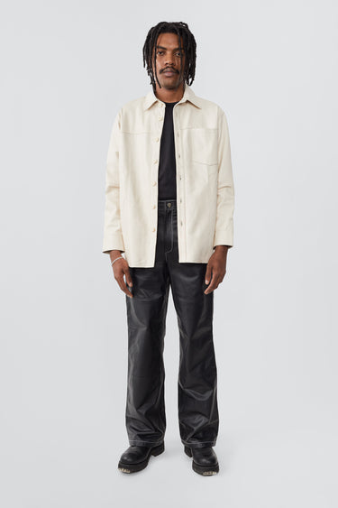 Model in off-white Spike Shirt by Deadwood, relaxed-fit leather overshirt with recycled PET lining.